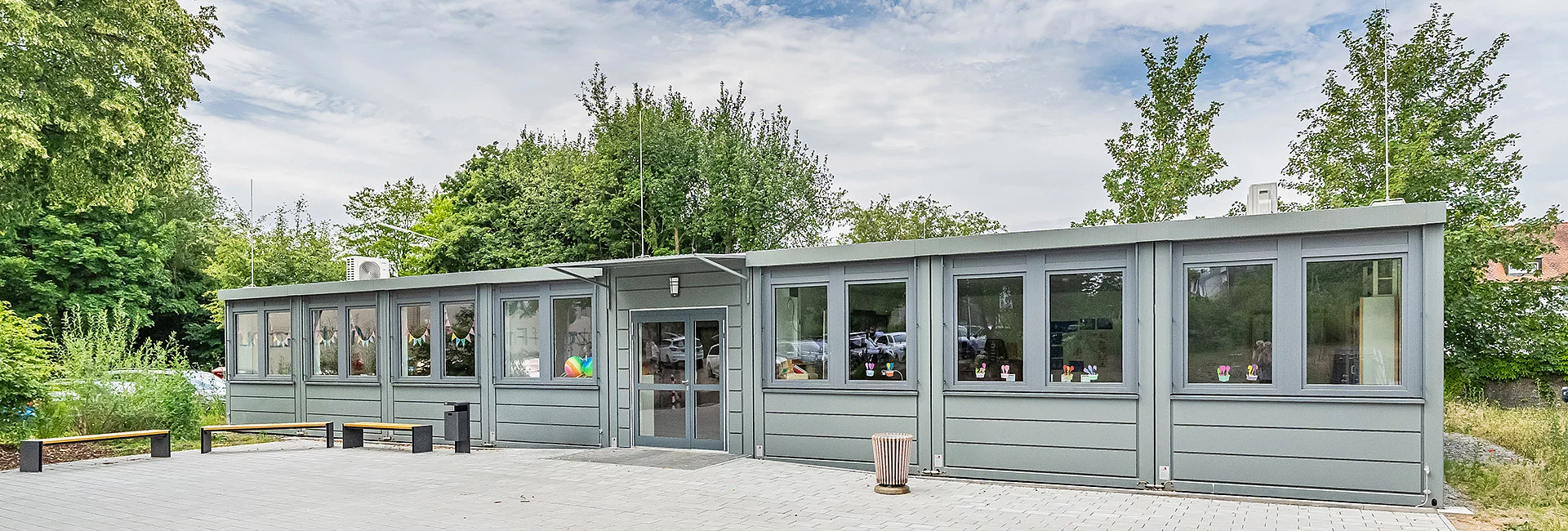Moderne Containeranlage des Förderzentrums Vohenstrauß mit barrierefreiem Eingangsbereich und großzügiger Pflasterfläche.