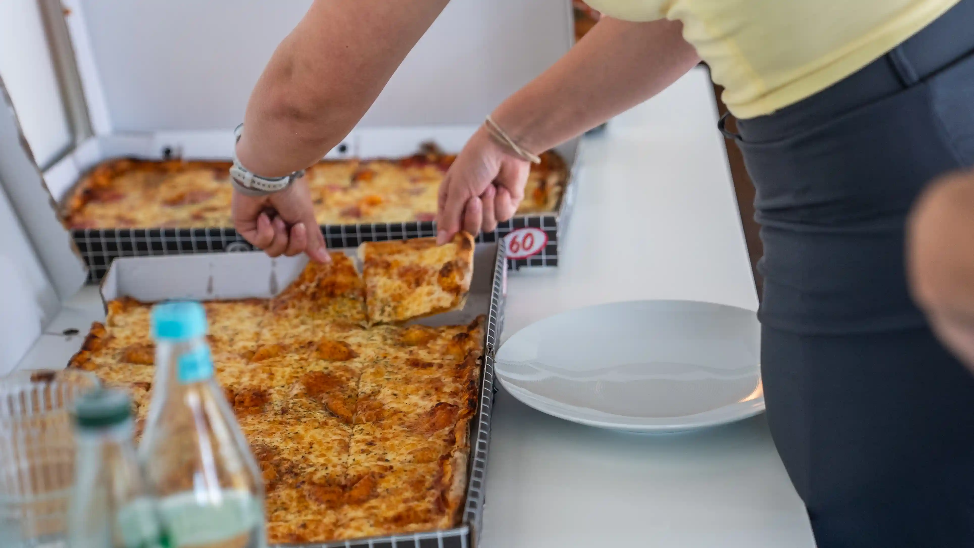 Frisch gebackene Pizza wird in Kartons zum Mittagessen aufgeteilt