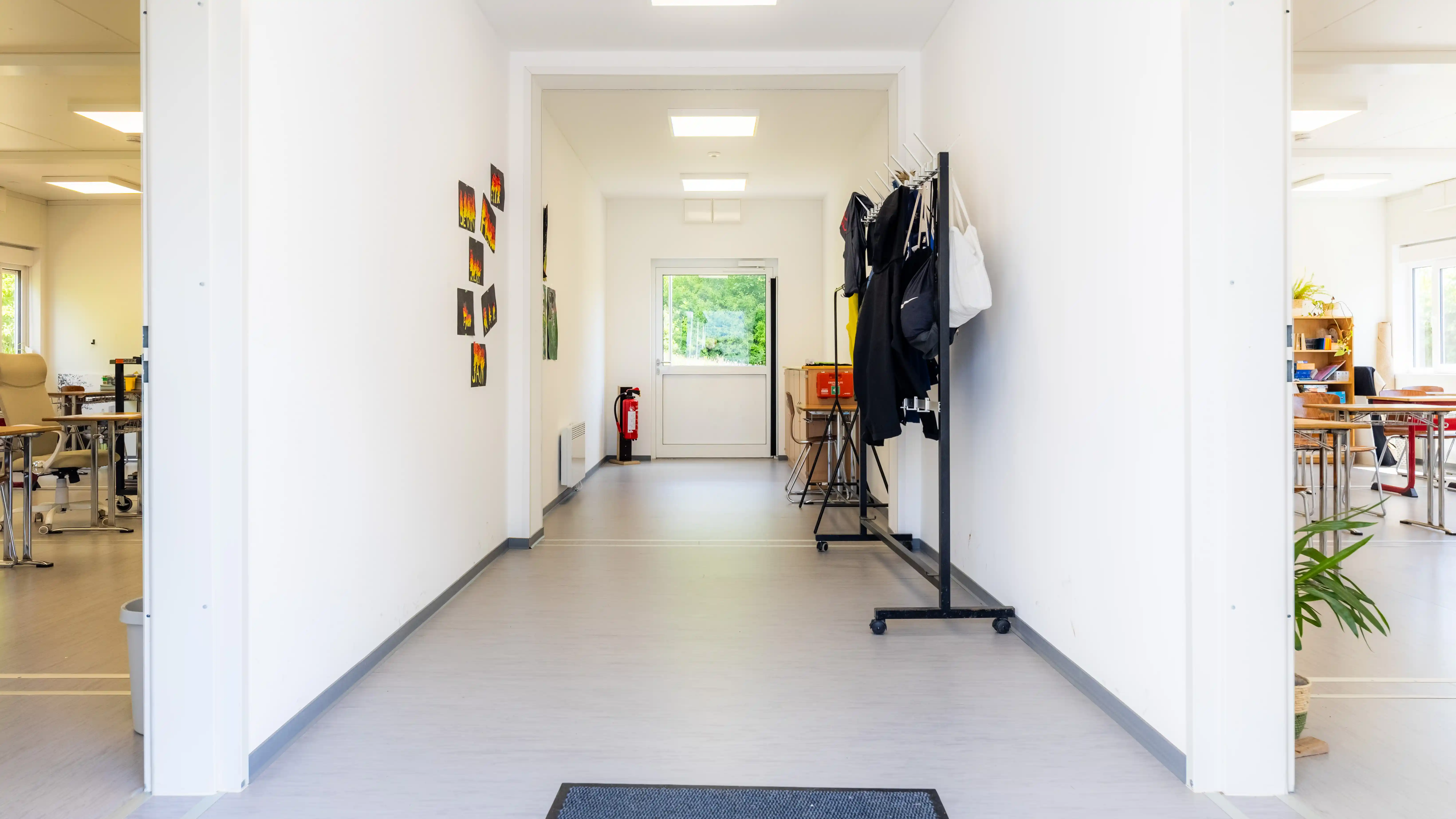 Moderner Flurbereich in der temporären Schulcontaineranlage der Pestalozzi-Schule in Kronach mit Garderoben und Zugang zu den Klassenräumen.