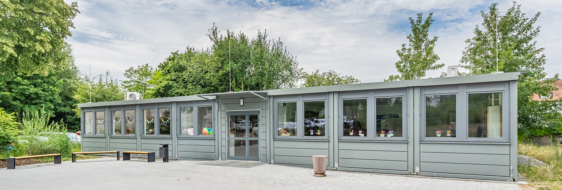 Moderne Containeranlage des Förderzentrums Vohenstrauß mit barrierefreiem Eingangsbereich und großzügiger Pflasterfläche.